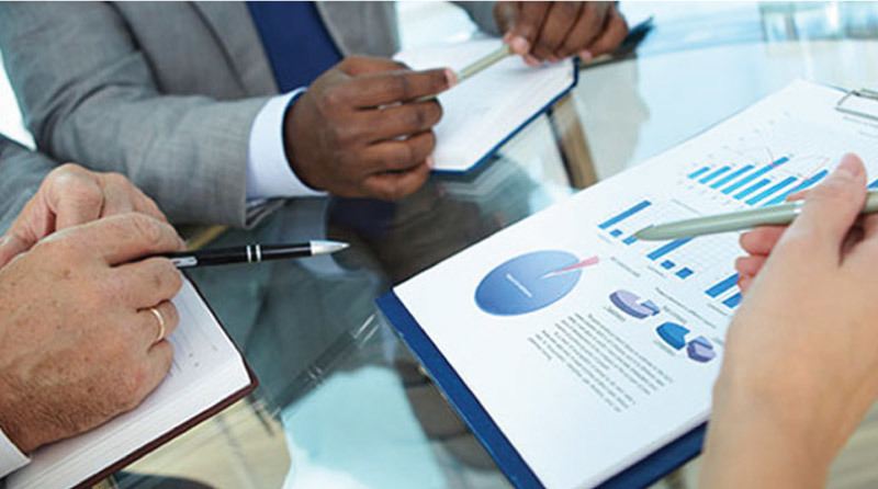Consultants reviewing charts and reports at a meeting